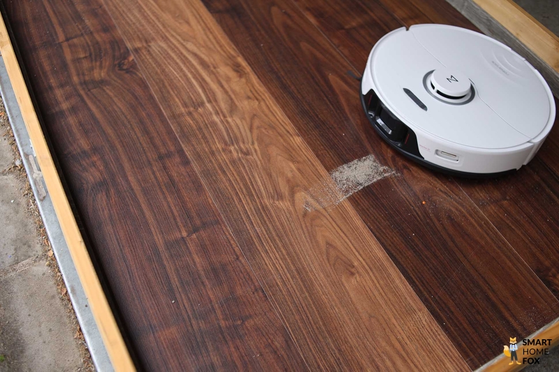 Roborock S8 Pro Ultra убирает песок в тесте на мощность всасывания на ламинате.